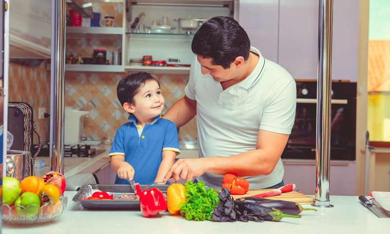 Father and young son cooking together