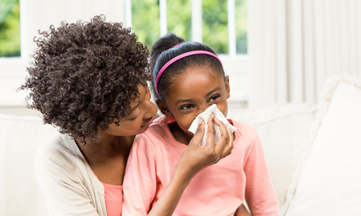 Mom helping child blow her nose