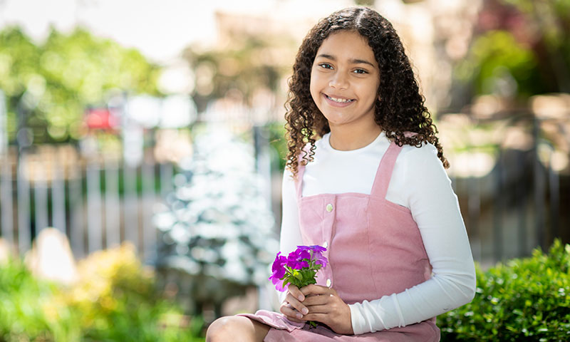 Little girl holding flowers while posing for a picture
