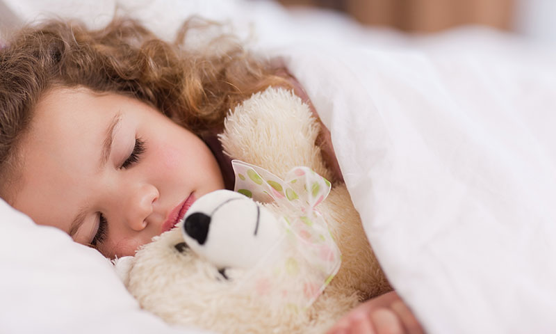 little girl sleeping holding a teddy bear