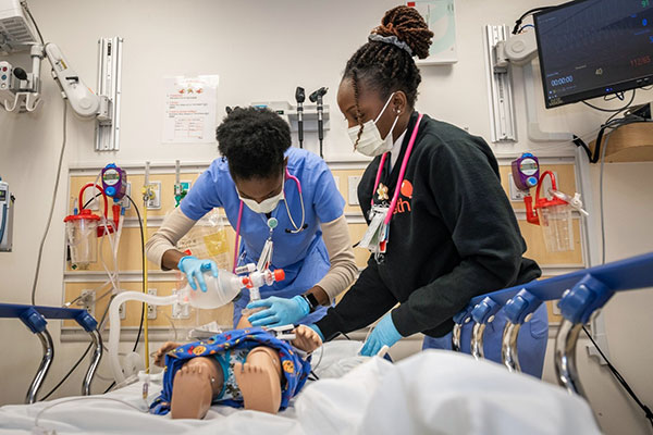 Nurse residents working with a stimulation doll