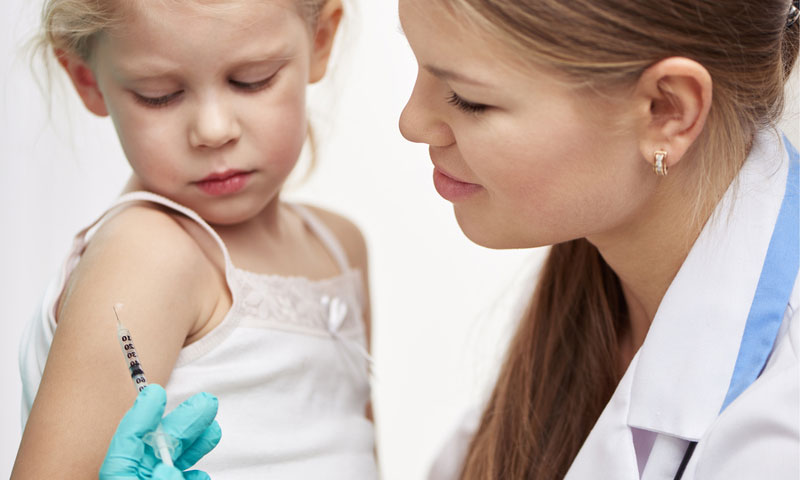 Female physician vaccinating little child