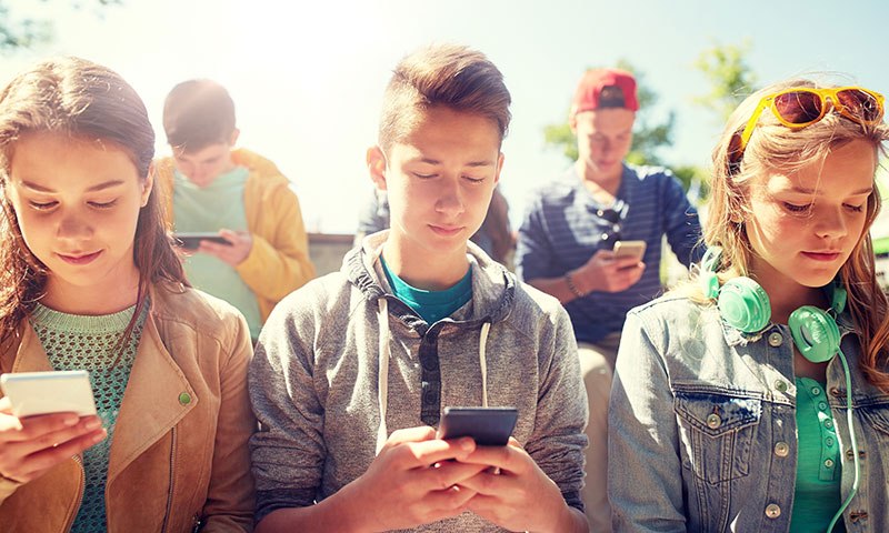 Teens staring at their phones