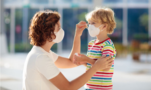 Parent helping child with mask