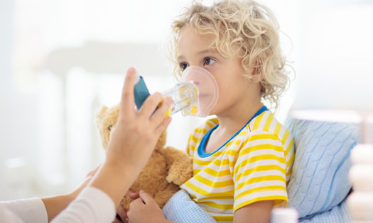 child using asthma inhaler at home