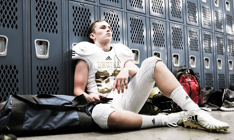 Hunter sitting against lockers in locker room