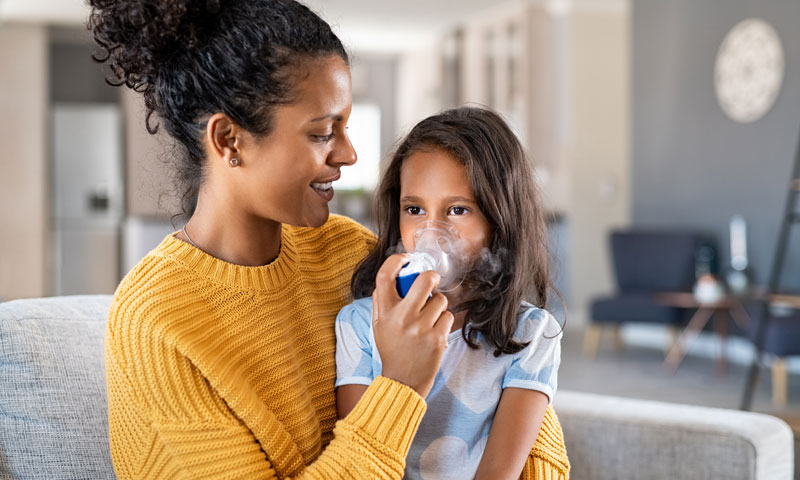 Mother helping daughter with inhaler