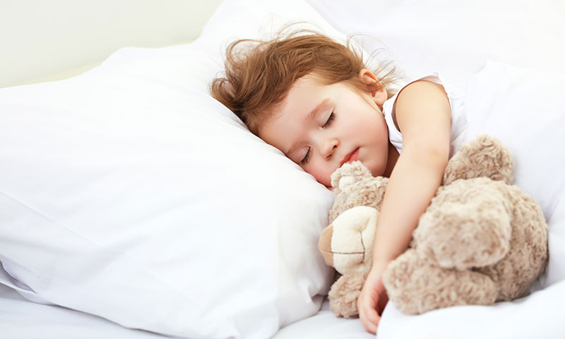little girl sleeping with her teddy bear