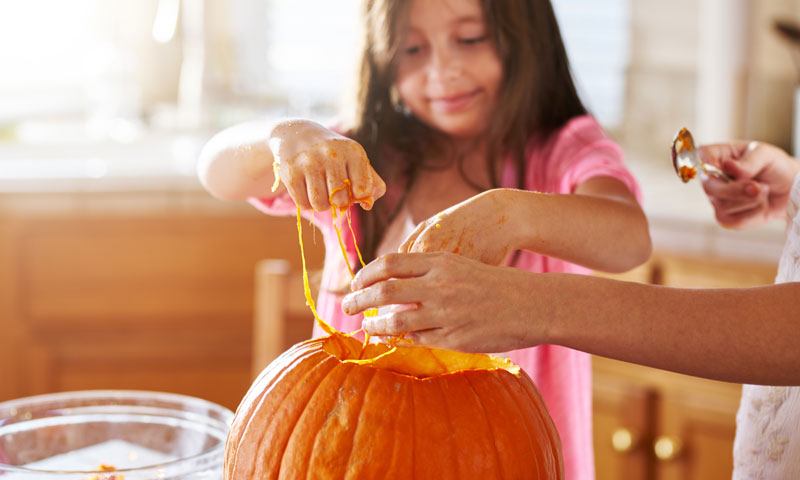 Mother and daughter cutting up pumpkin