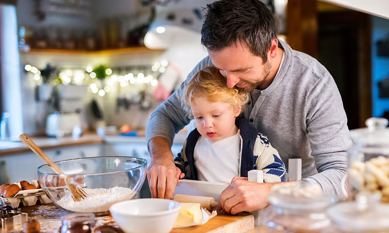 single father making holiday cookies with son