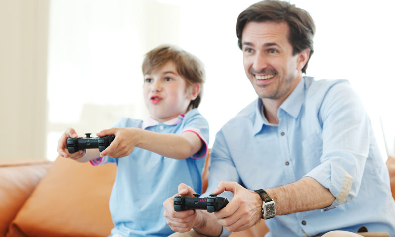 Father and son playing video games together and having fun