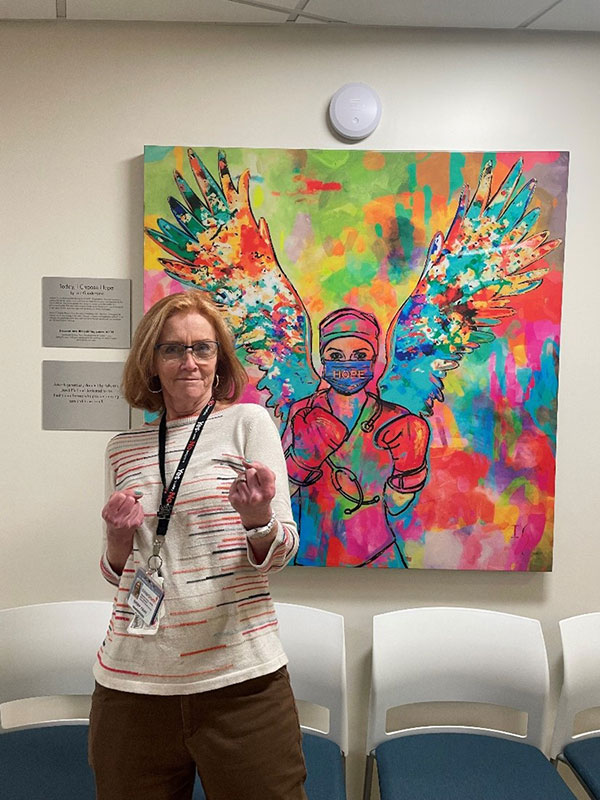 Happy woman smiling in front of artwork