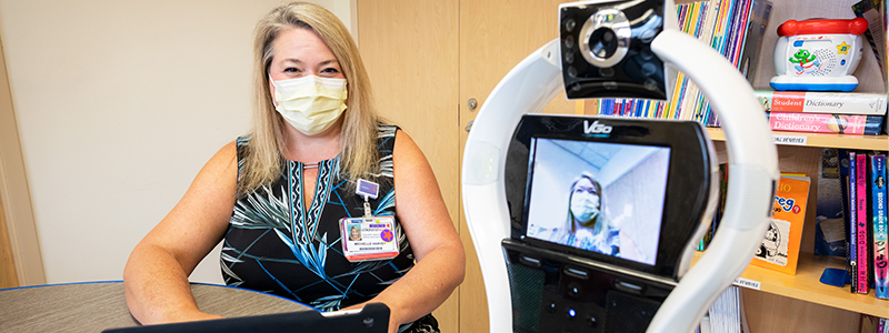 Michelle Harvery is stetting up one of the VGO Robots in the classroom at Children's Health.