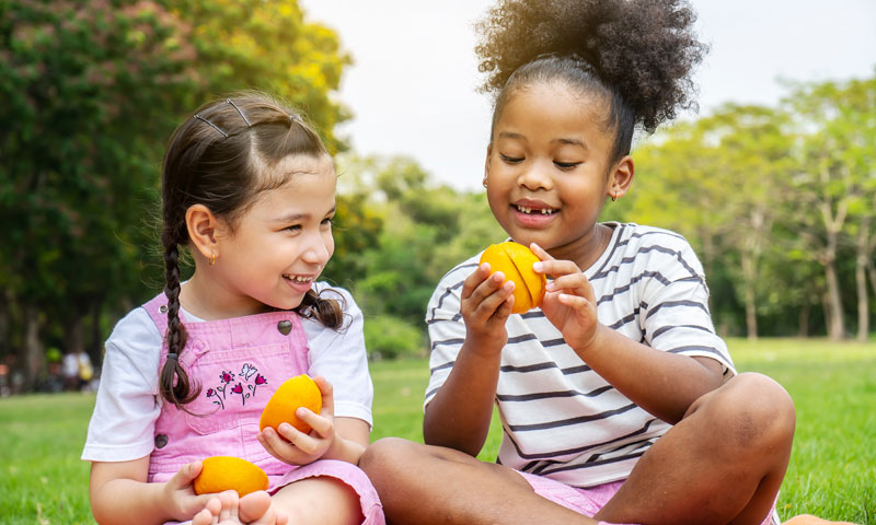 Girls eating oranges outside