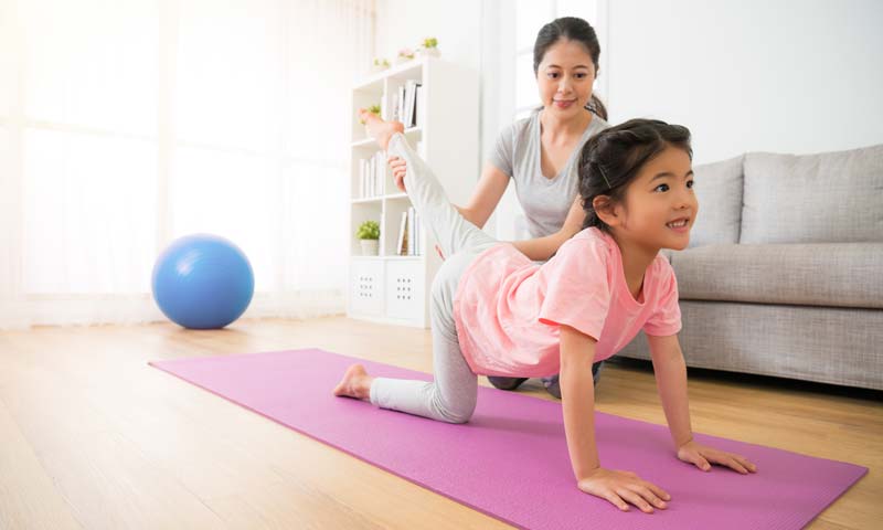 Mother and daughter practicing yoga together