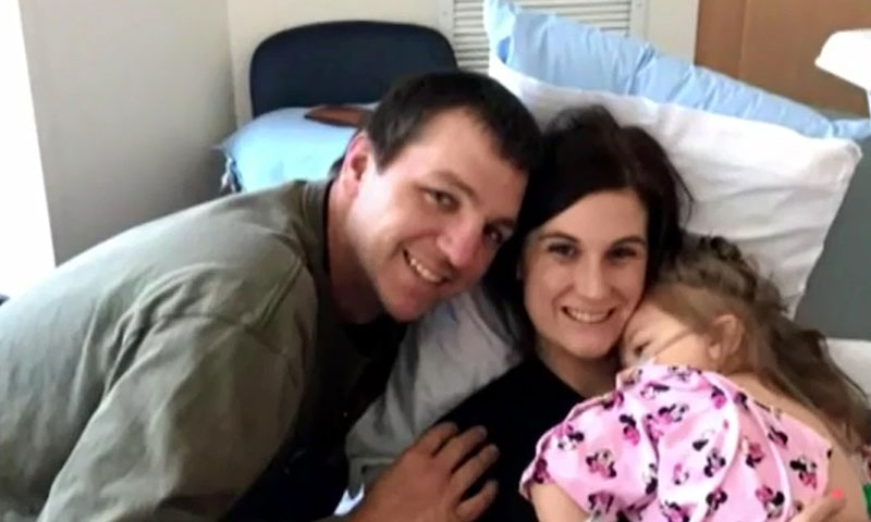 family of mother father and child embrace each other at hospital