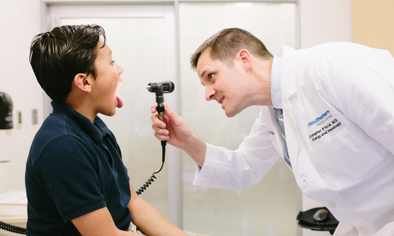 Doctor checking back of patients throat