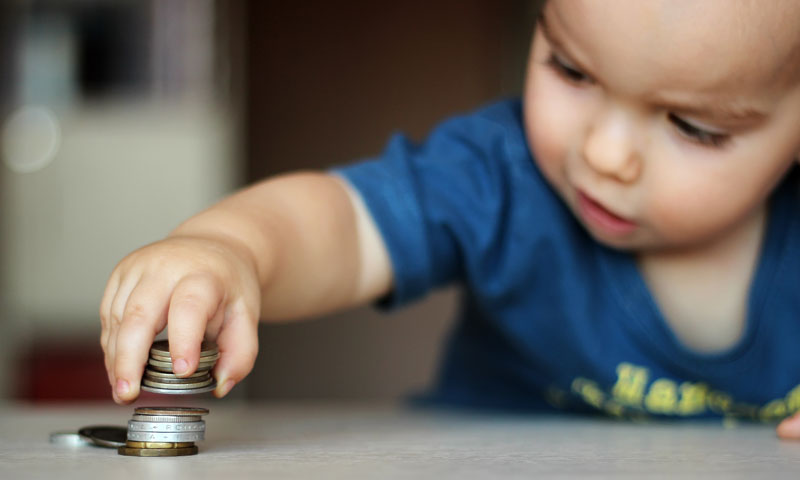 Little boy playing with coins