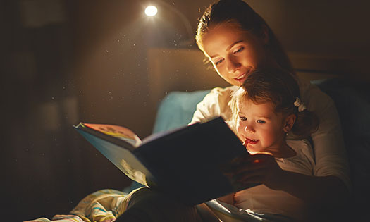 mother reading daughter bed time story