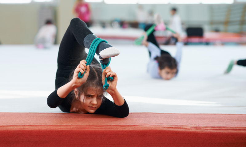 young gymnast stretches her back