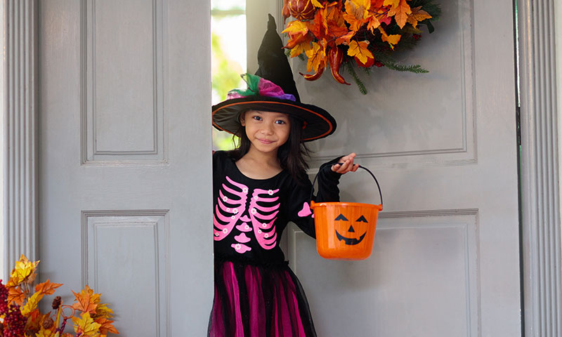 Little girl with Halloween candy bucket