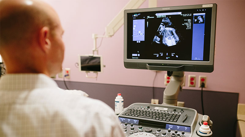 doctor looks at the sonogram screen