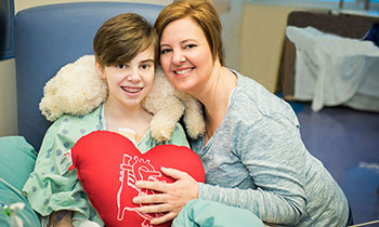 Smiling child and mother on hospital bed
