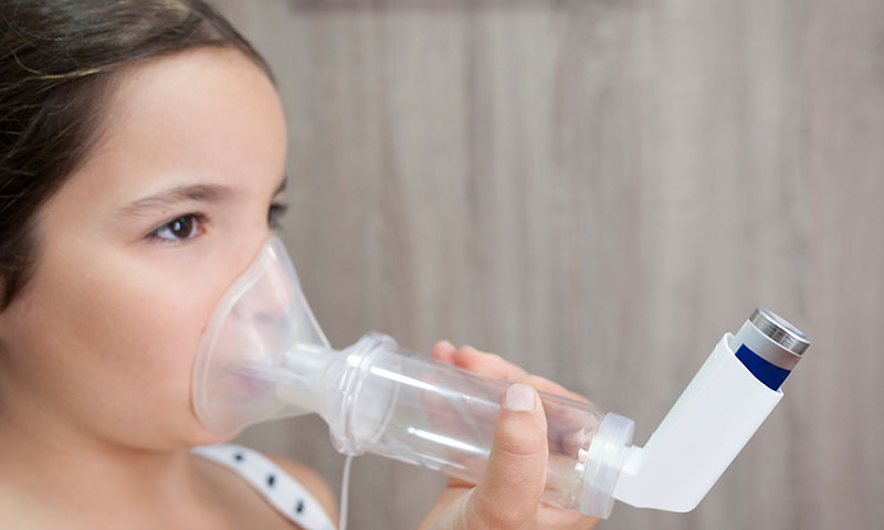 Little girl using an inhaler