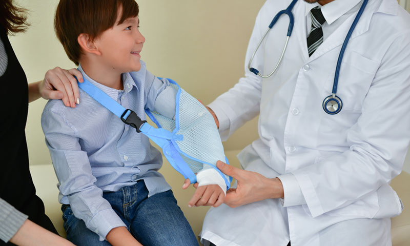doctor checking out little boys cast 