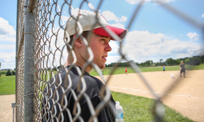 Injured baseball player watching game from sidelines