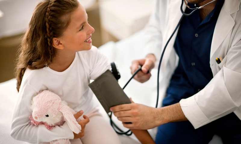 Nurse checking little girls blood pressure