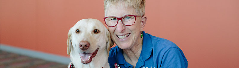 Volunteer posing with therapy dog